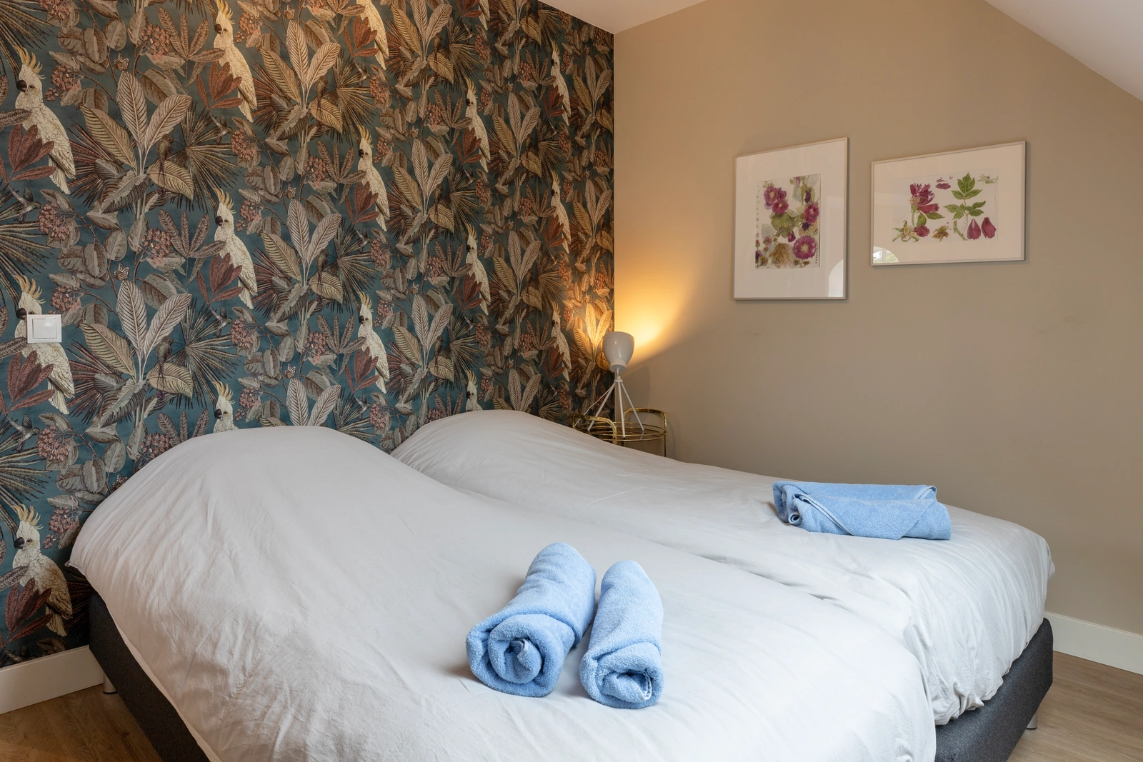Slaapkamer met opgemaakte bedden en blauwe handdoeken in appartement Alexander